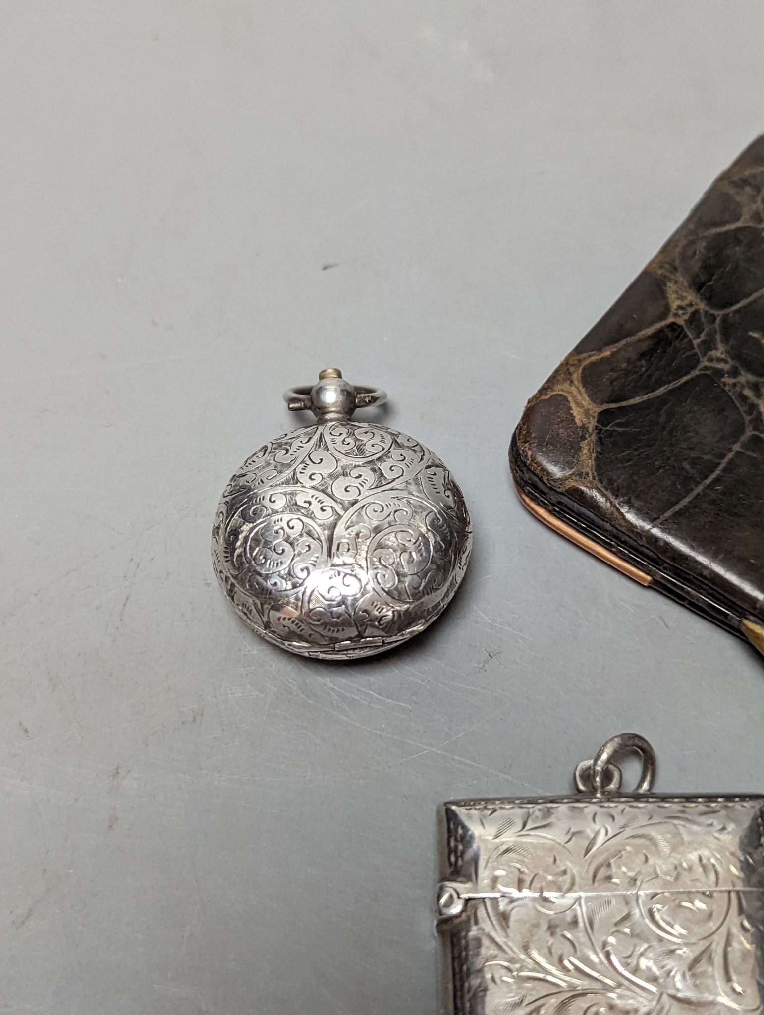 A late Victorian engraved silver sovereign case, a silver vesta case and an Edwardian 9ct gold mounted leather card purse.